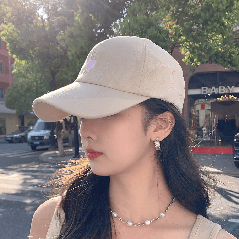 Woman wearing stylish adjustable cotton baseball cap with trendy letter pattern, perfect for casual outings and sports activities.
